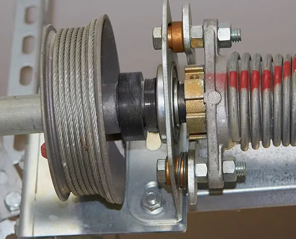 Close-up of garage door cable and pulley system showing mechanical parts.